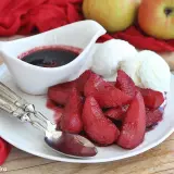 Pere cotte nel vino, un dolcetto invitante con gelato alla vaniglia e una salsa scura.