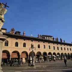 Statua e portici decorati in Piazza Ducale, un luogo imperdibile tra le cose da vedere a Vigevano.