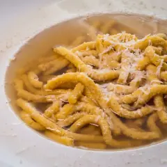 Passatelli in brodo, un classico dei cibi tipici dell'Emilia Romagna, con abbondante parmigiano grattugiato.