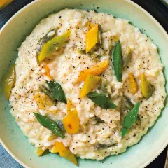 Risotto alla vogherese cremoso, guarnito con peperoni gialli e verdi a listarelle e pepe nero macinato.