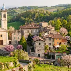 Borgo pittoresco con chiesa e campanile, colline verdi e fiori in primavera. Un luogo incantevole da scoprire, un vero gioiello per chi cerca cosa vedere a Golferenzo.