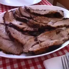 Fette di petto di vitella succulento, affettate e servite su un piatto bianco, pronte per essere gustate.