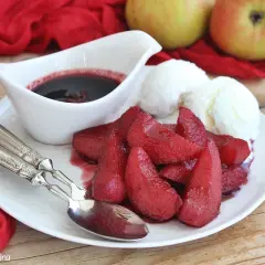 Pere cotte nel vino, un dolcetto invitante con gelato alla vaniglia e una salsa scura.