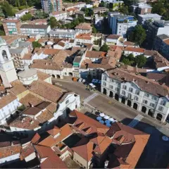 Vista aerea di un paese con campanile, tetti rossi e palazzi storici. Un luogo dove ci sono molti **broni cosa vedere**.