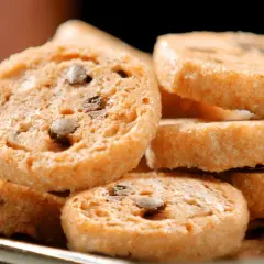 Biscotti tipici italiani con gocce di cioccolato, impilati su un piatto.