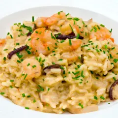Un cremoso risotto funghi e gamberetti, guarnito con erba cipollina fresca.