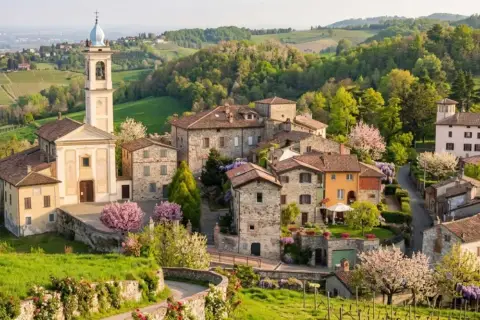 Borgo pittoresco con chiesa e campanile, colline verdi e fiori in primavera. Un luogo incantevole da scoprire, un vero gioiello per chi cerca cosa vedere a Golferenzo.