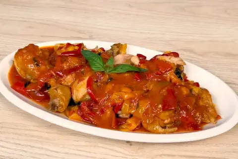 Un saporito pollo con peperoni, cotto in una ricca salsa rossa, guarnito con basilico fresco.