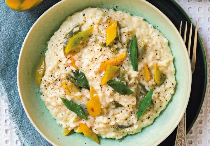 Risotto alla vogherese cremoso, guarnito con peperoni gialli e verdi a listarelle e pepe nero macinato.