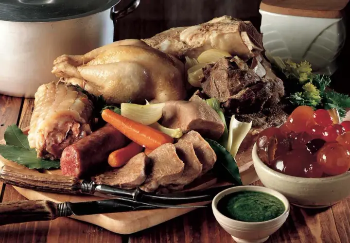 Un ricco bollito con mostarda, composto da pollo, lingua, salumi e verdure, pronto per essere gustato.
