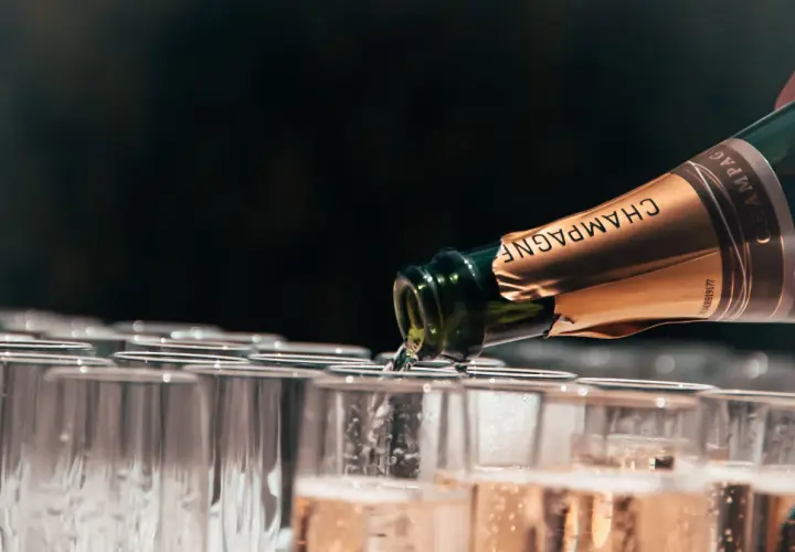 Versando champagne, un brindisi alle migliori annate. Bollicine dorate riempiono i calici in attesa.