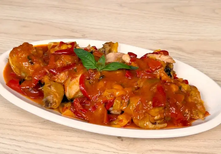Un saporito pollo con peperoni, cotto in una ricca salsa rossa, guarnito con basilico fresco.