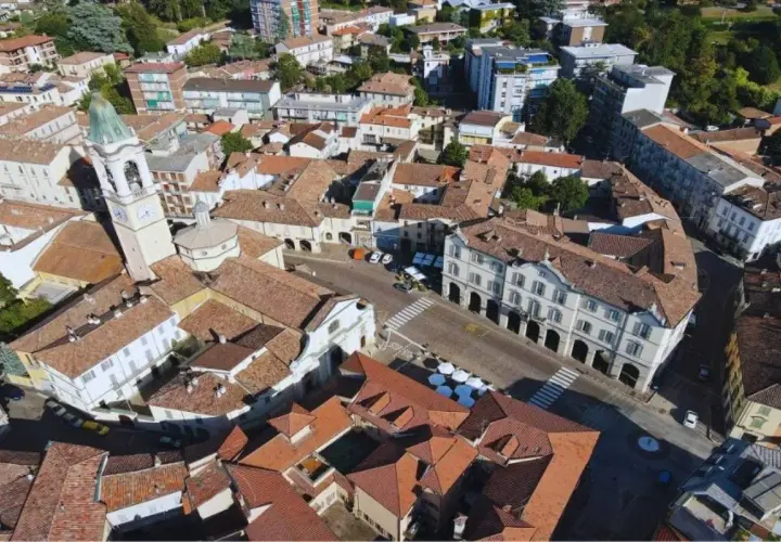 Vista aerea di un paese con campanile, tetti rossi e palazzi storici. Un luogo dove ci sono molti **broni cosa vedere**.
