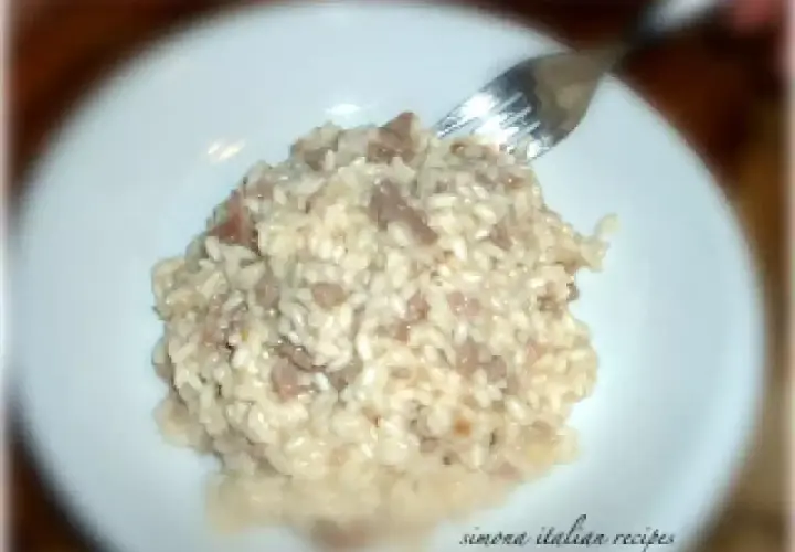 Un cremoso risotto con pasta di salame, pronto per essere gustato.
