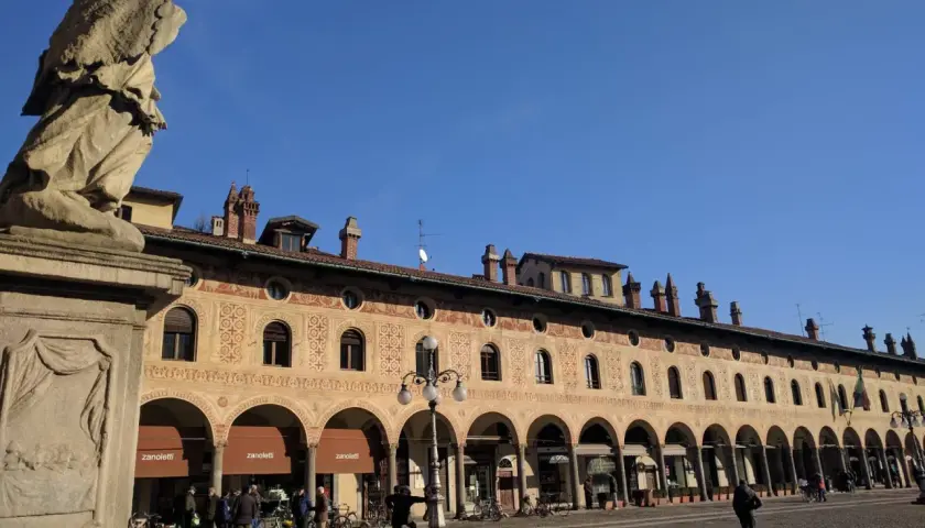 Statua e portici decorati in Piazza Ducale, un luogo imperdibile tra le cose da vedere a Vigevano.