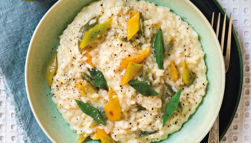 Risotto alla vogherese cremoso, guarnito con peperoni gialli e verdi a listarelle e pepe nero macinato.