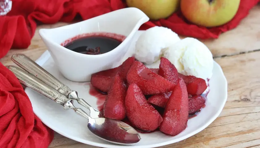 Pere cotte nel vino, un dolcetto invitante con gelato alla vaniglia e una salsa scura.