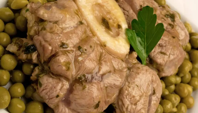 Ossobuco ricetta con piselli, un piatto succulento e saporito, pronto per essere gustato.