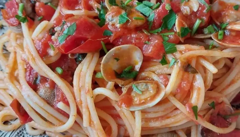Spaghetti con lupini e pomodorini freschi, un piatto estivo che profuma di mare e sole.