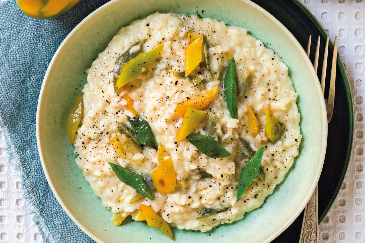 Risotto alla vogherese cremoso, guarnito con peperoni gialli e verdi a listarelle e pepe nero macinato.