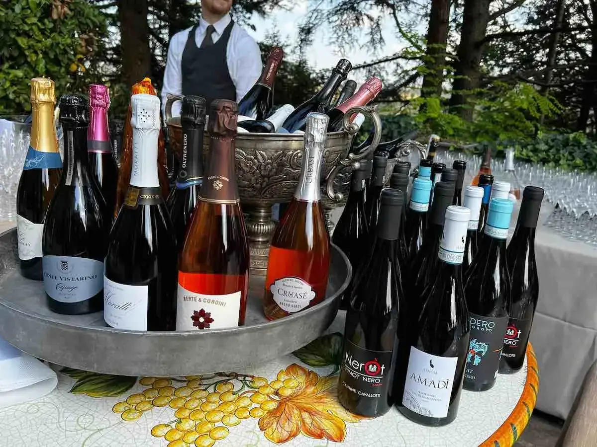 Bottiglie di vino, tra cui Pinot Nero, pronte per essere servite in un evento all'aperto.