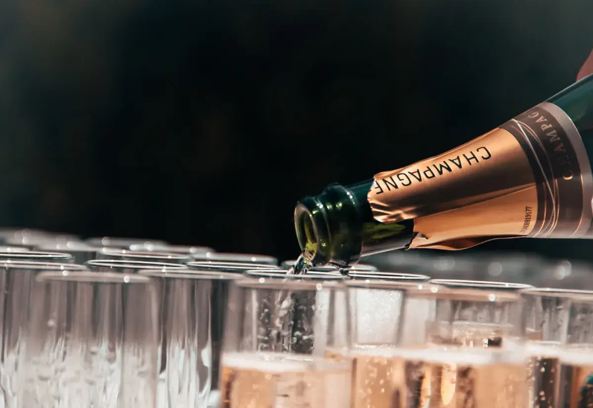 Versando champagne, un brindisi alle migliori annate. Bollicine dorate riempiono i calici in attesa.
