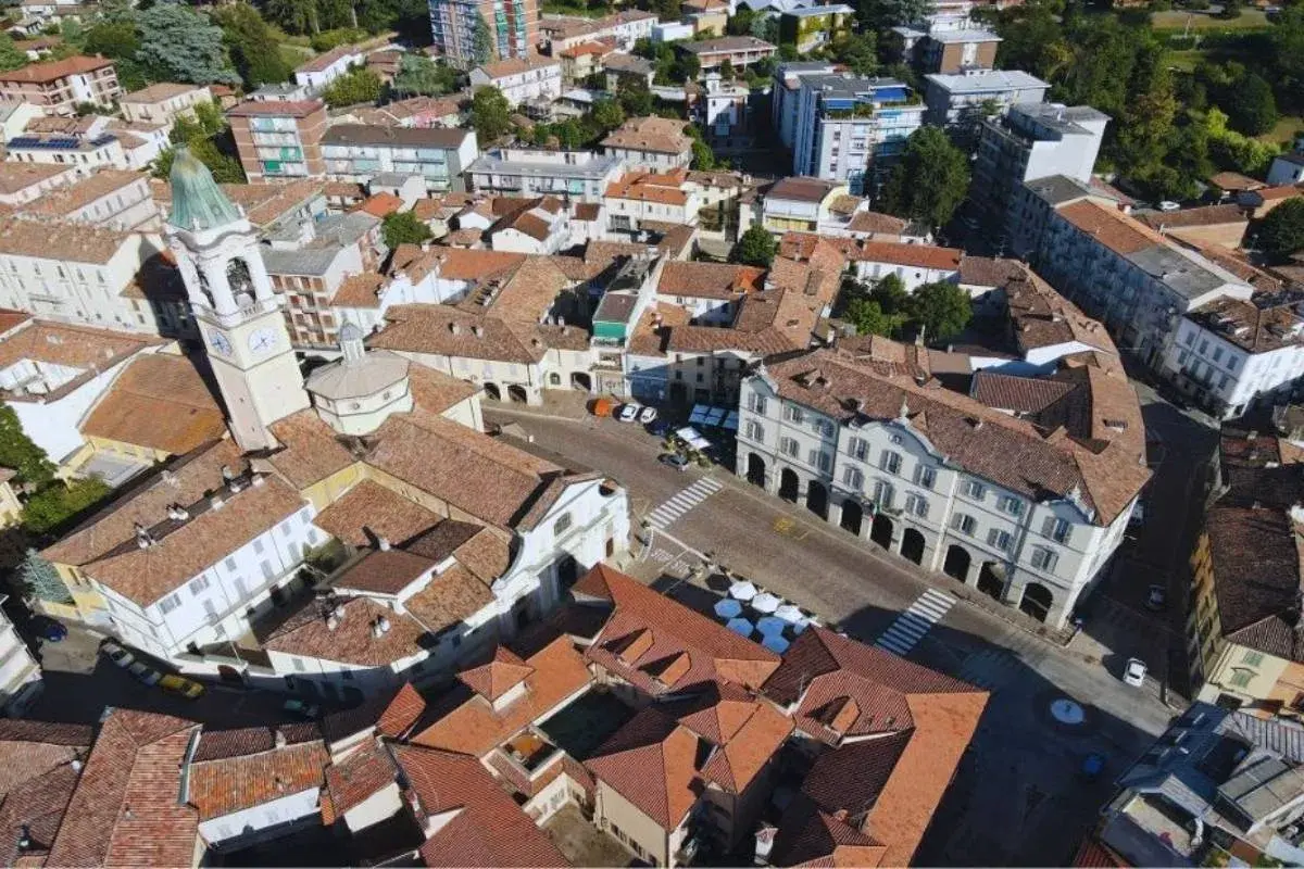 Vista aerea di un paese con campanile, tetti rossi e palazzi storici. Un luogo dove ci sono molti **broni cosa vedere**.