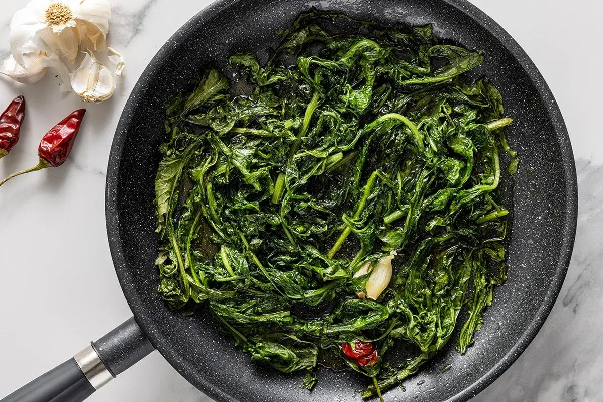 Padella con verdure saltate, aglio e peperoncino. Un'idea per gustose tarassaco ricette.
