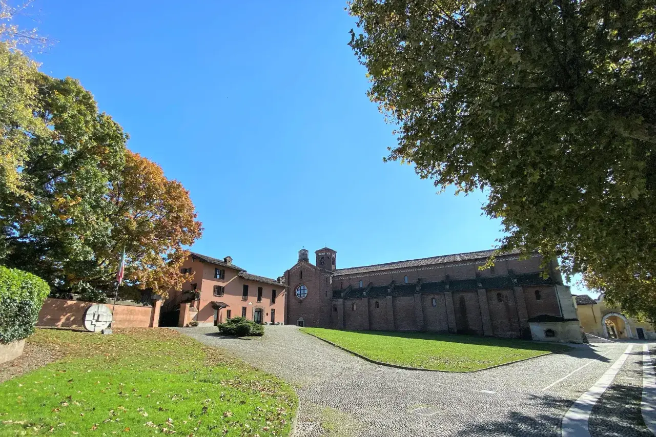 Abbazia di Morimondo: cosa vedere in questo luogo storico con la sua imponente chiesa in mattoni rossi e il verde dei giardini autunnali.