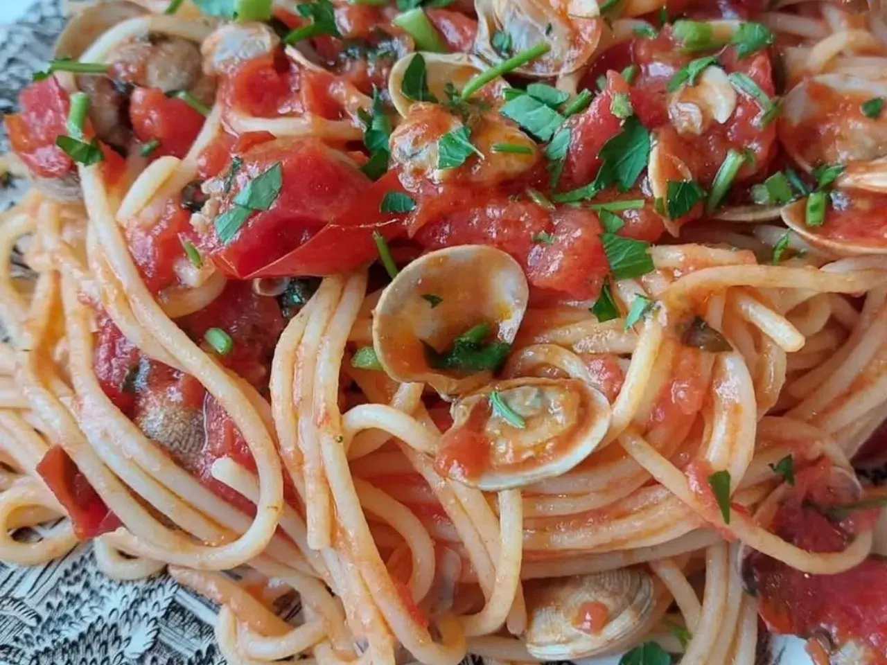 Spaghetti con lupini e pomodorini freschi, un piatto estivo che profuma di mare e sole.