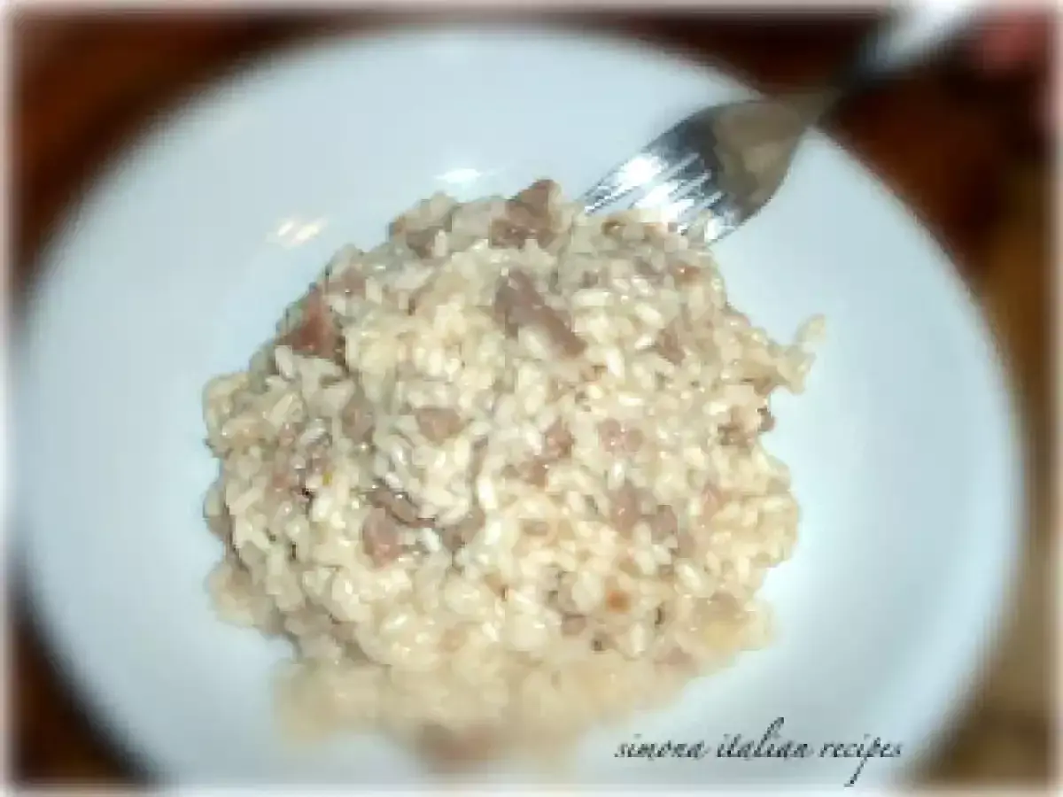 Un cremoso risotto con pasta di salame, pronto per essere gustato.