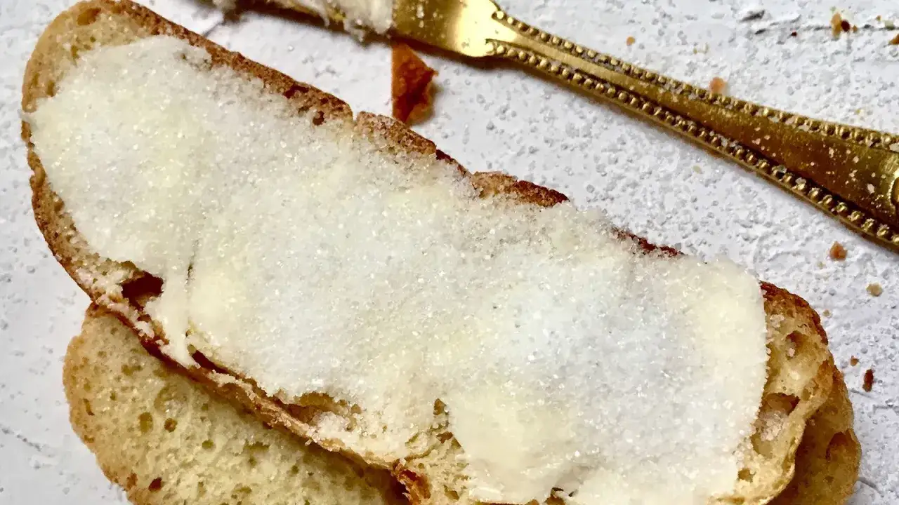 Fetta di pane con burro e zucchero, un classico semplice e goloso.