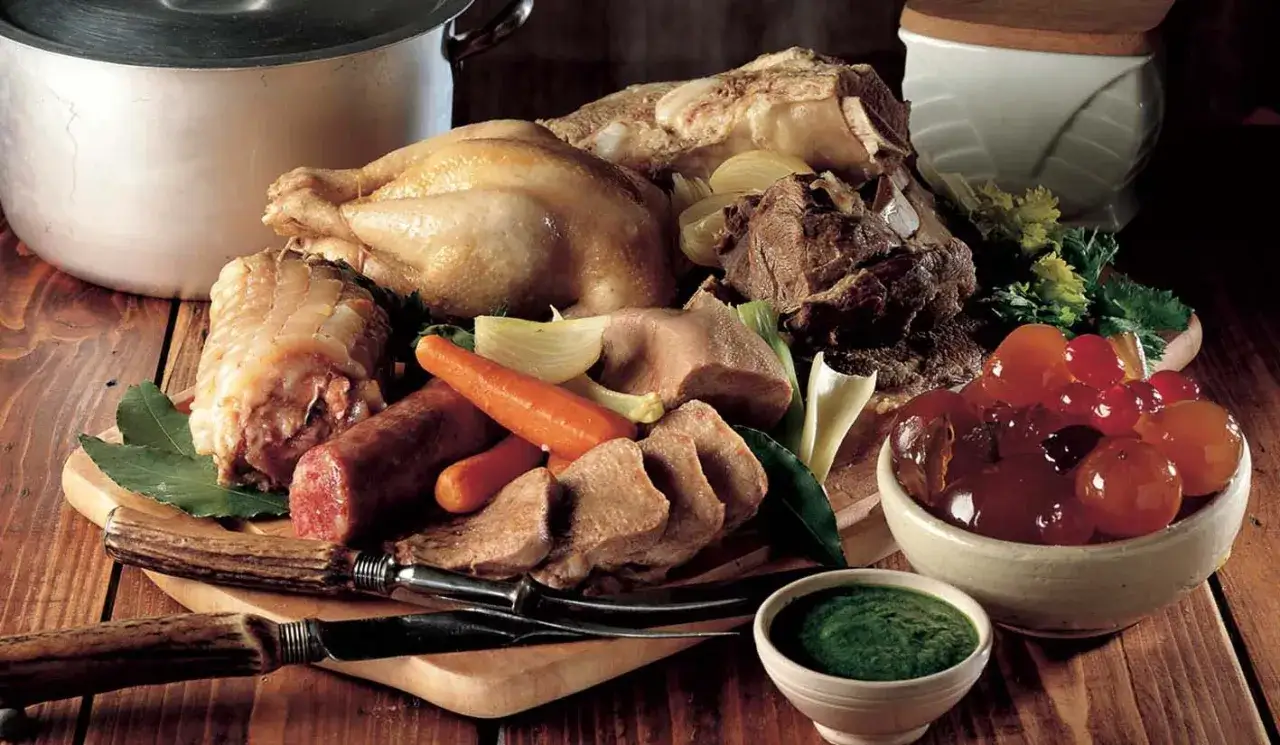 Un ricco bollito con mostarda, pollo, lingua, salsiccia e verdure, pronto per essere gustato.