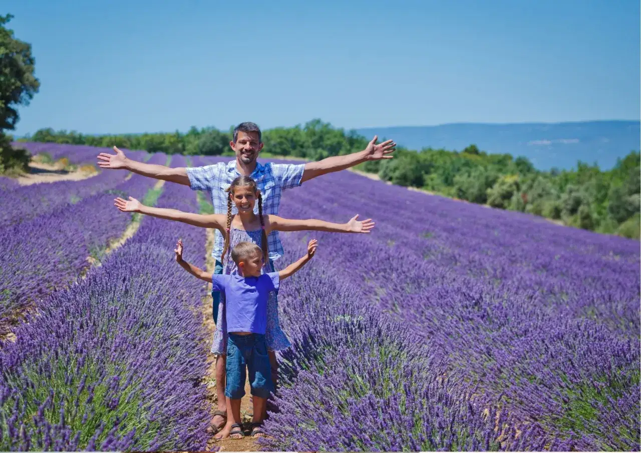 Famiglia felice in un campo di lavanda, con le braccia aperte per abbracciare la bellezza profumata.