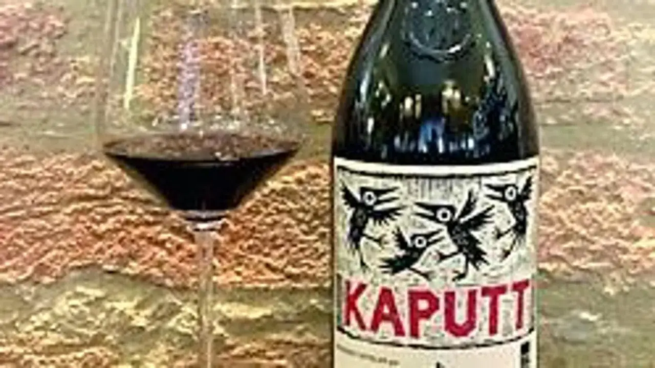 Calice di vino rosso accanto a una bottiglia di vino costoso 