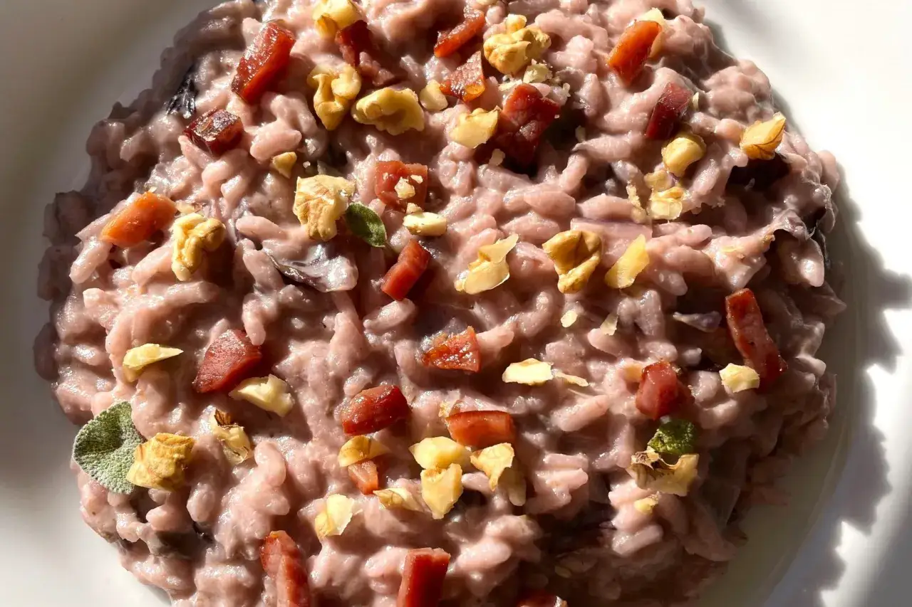 Risotto cremoso alla robiola con cubetti di speck croccante e noci.