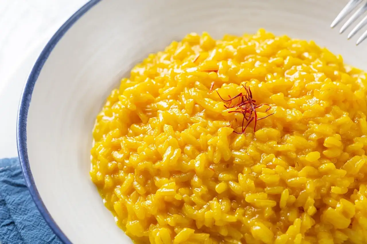 Risotto alla Milanese, uno dei piatti tipici lombardia, cremoso e profumato con pistilli di zafferano.