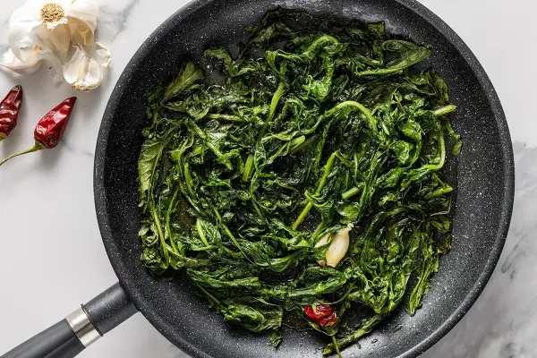 Padella con verdure saltate, aglio e peperoncino. Un'idea per gustose tarassaco ricette.